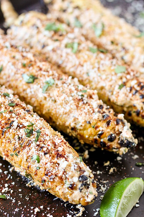 Fresh ears of corn are grilled until browned and smoky then coated in a mixture of sour cream, mayo, chili powder, and cotija cheese. Topped with fresh lime juice, this Grilled Mexican Street Corn is the perfect version of Mexican Elote!