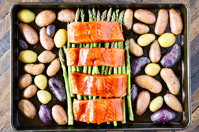 This Sheet Pan Salmon Dinner recipe is so easy to make and absolutely loaded with flavor! Glazed salmon with garlicky roasted potatoes and asparagus and everything cooks on the same pan