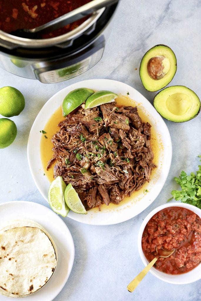 Barbacoa Beef served with avocados, fresh limes, salsa and tortillas.